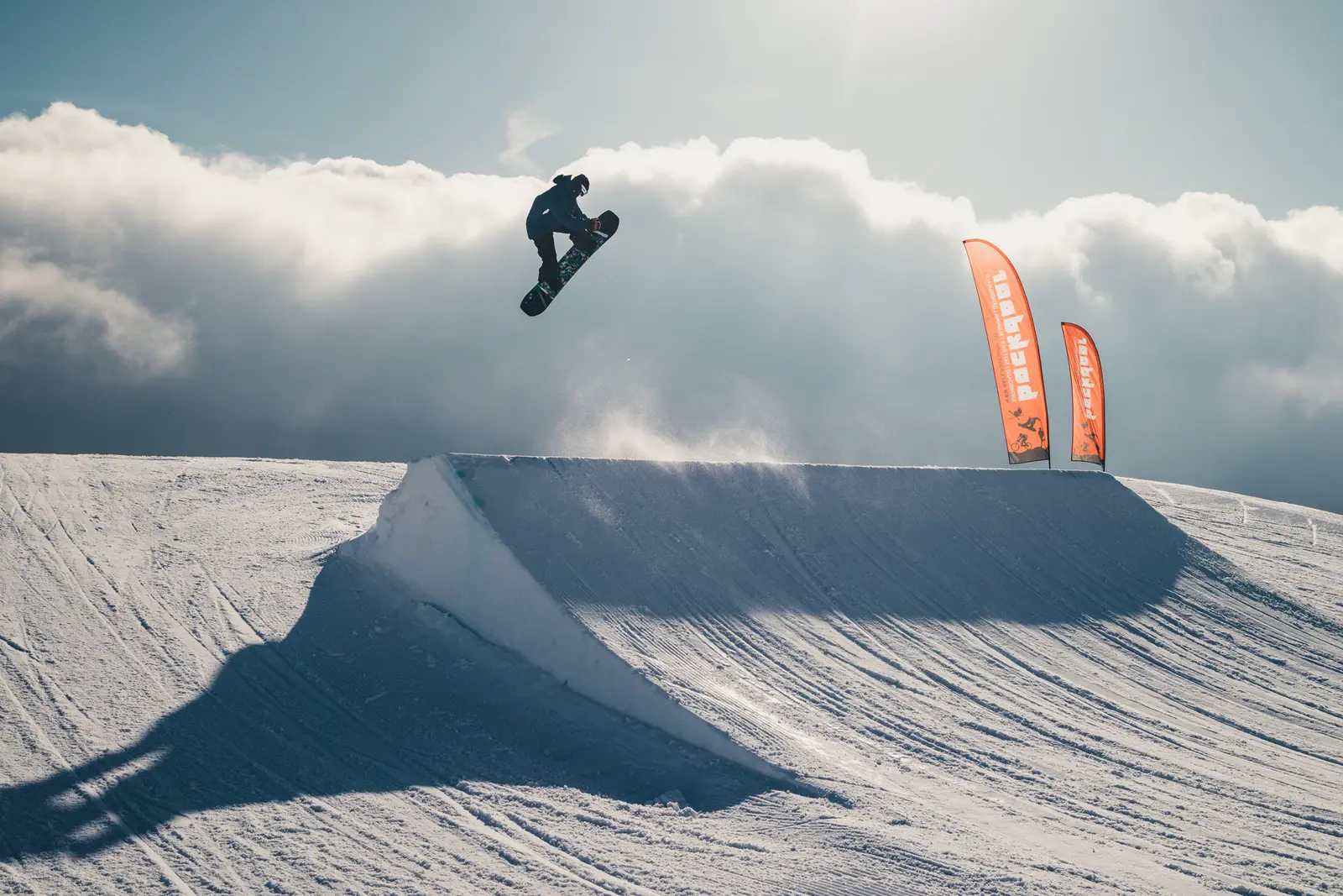 Snowboarder mit Method Grab über dem Kicker